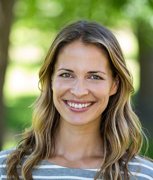 A portrait of a woman smiling outdoors