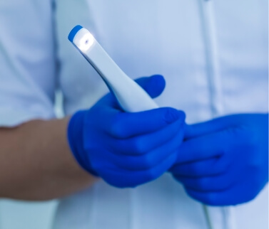 Dental team member holding a white pen like intraoral camera