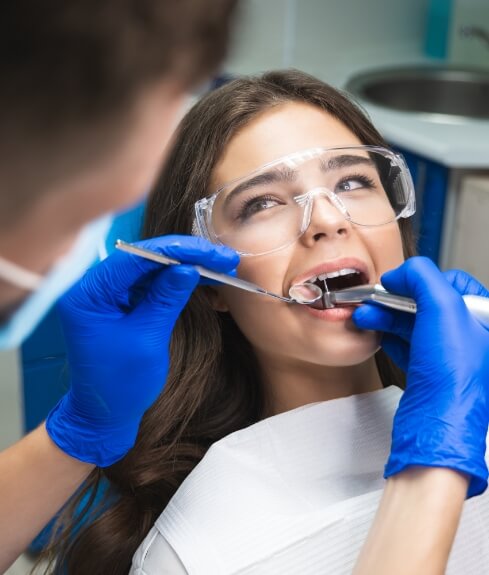 Young woman in dental chair receiving root canal treatment in Worcester